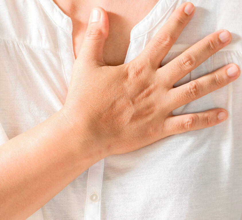 Woman is clutching her chest