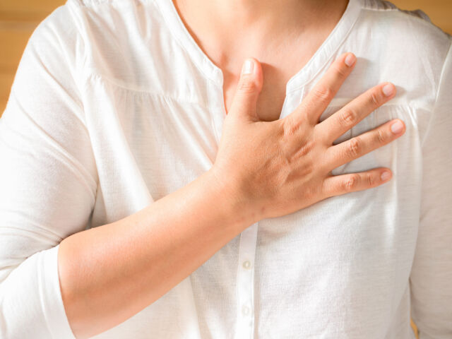 Woman is clutching her chest